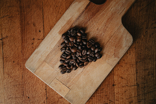 Fresh coffee beans arranged in a heart shape