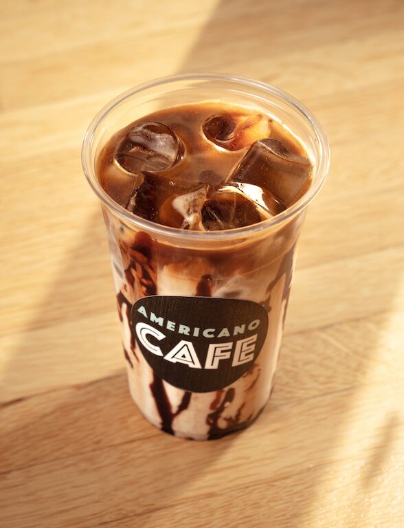 Iced coffee on a wood table at Americano Cafe