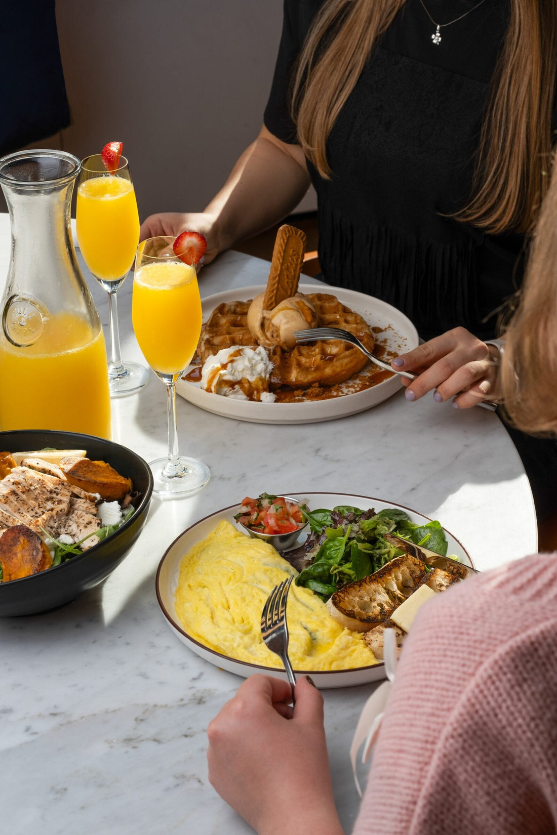 Weekend brunch spread with mimosas and waffles at Americano Cafe