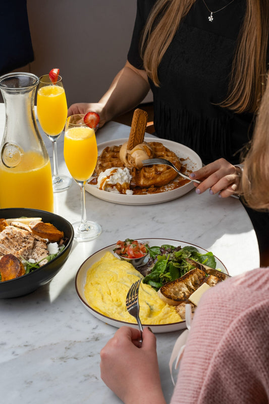 Weekend brunch spread with mimosas and waffles at Americano Cafe